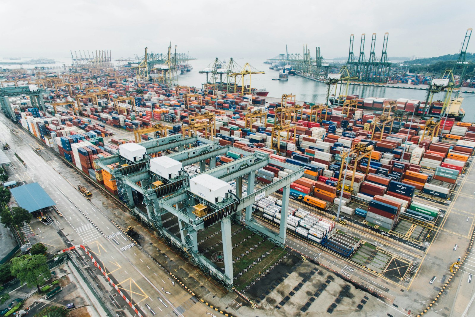 Stacked containers and cranes at a busy seaport terminal